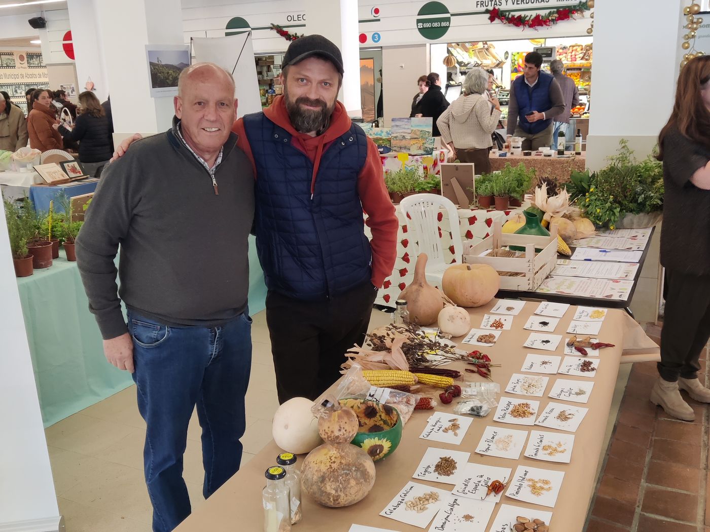 Dos socios en la mesa del mercadillo de semillas, en el mercado de abastos de Montilla